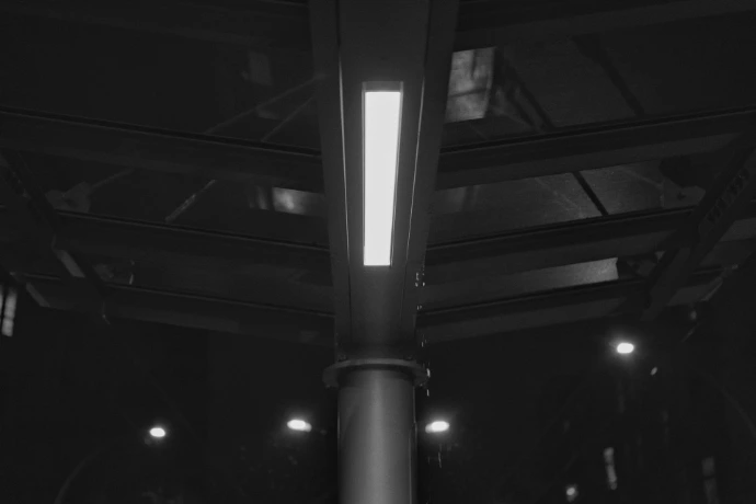 Fluorescent light fixture on dark ceiling structure